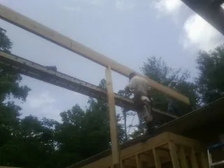 Carpenter setting a ridge beam over a new addition frame — Ice Dam Removal by Roofing Brothers in Rockwood